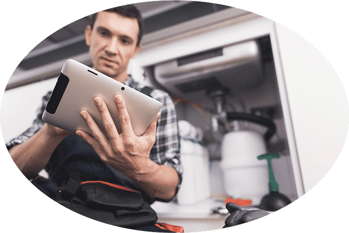 Image of a plumbing technician (plumber) with a Flat Rate Pricing Book on a Tablet PC